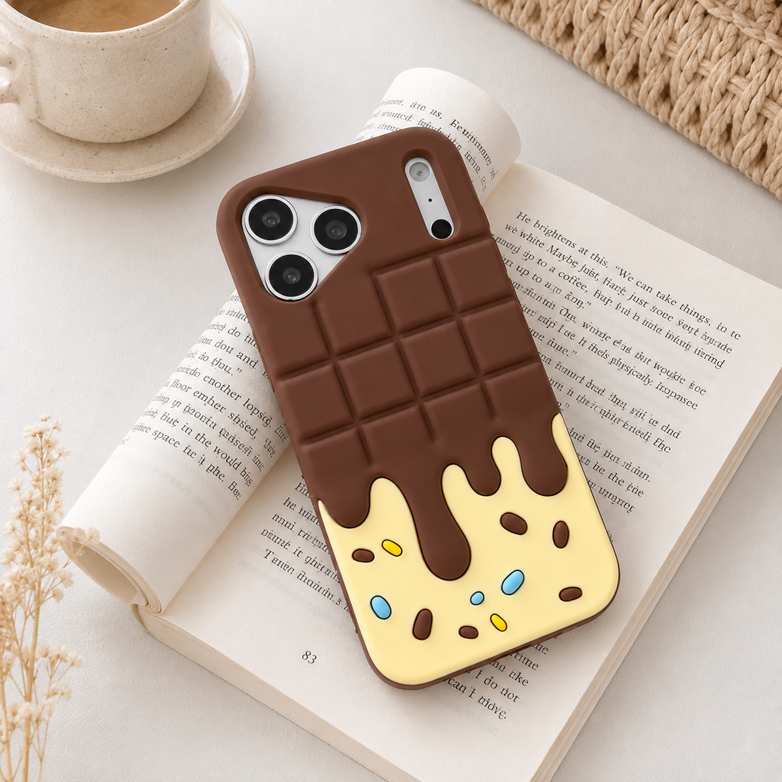 Coque iPhone 17 Pro Candy Chocolate marron crème mise en scène sur livre